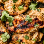 Tex-Mex grilled chicken with red pepper marinade, garnished with cilantro and lime